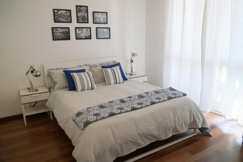 a bedroom with a large bed with blue pillows at Casa Lorelei in Sestri Levante