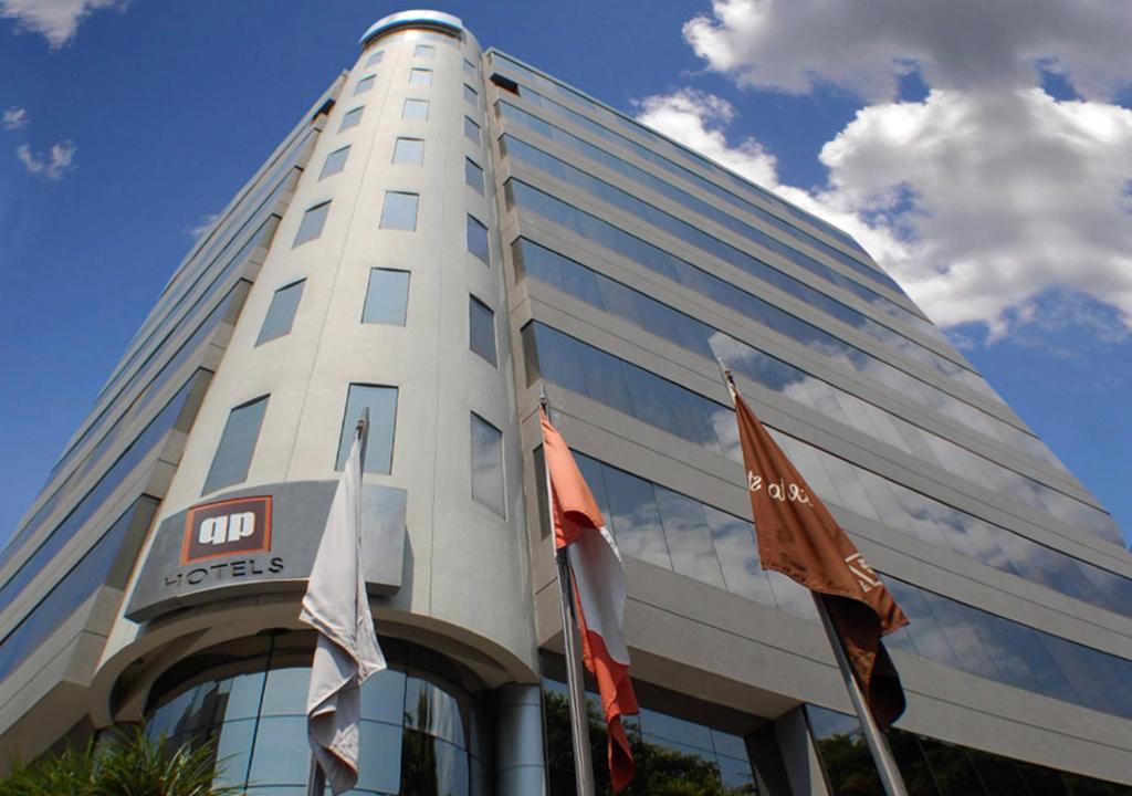 a tall white building with flags in front of it at qp Hotels Lima in Lima