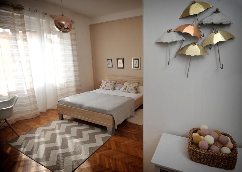 a bedroom with a bed with umbrellas on the wall at Celtis Apartment in Split