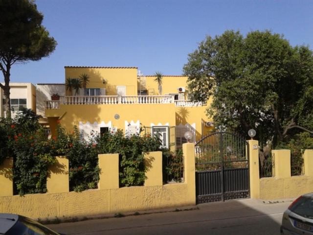 a yellow house with a fence in front of it at Villa Anastasia-Lampedusa in Lampedusa