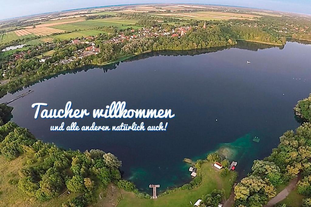 an aerial view of a lake with the words taylor willowman will aid at Pension Kolibri in Hemmoor