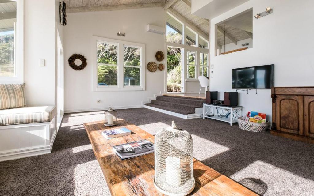 a living room with a couch and a table at Circular Bay in Awaroa