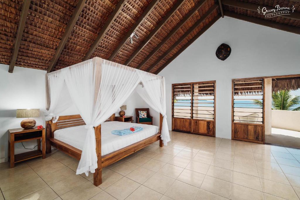 a bedroom with a bed with a mosquito net at Waves at Surfside in Port Vila