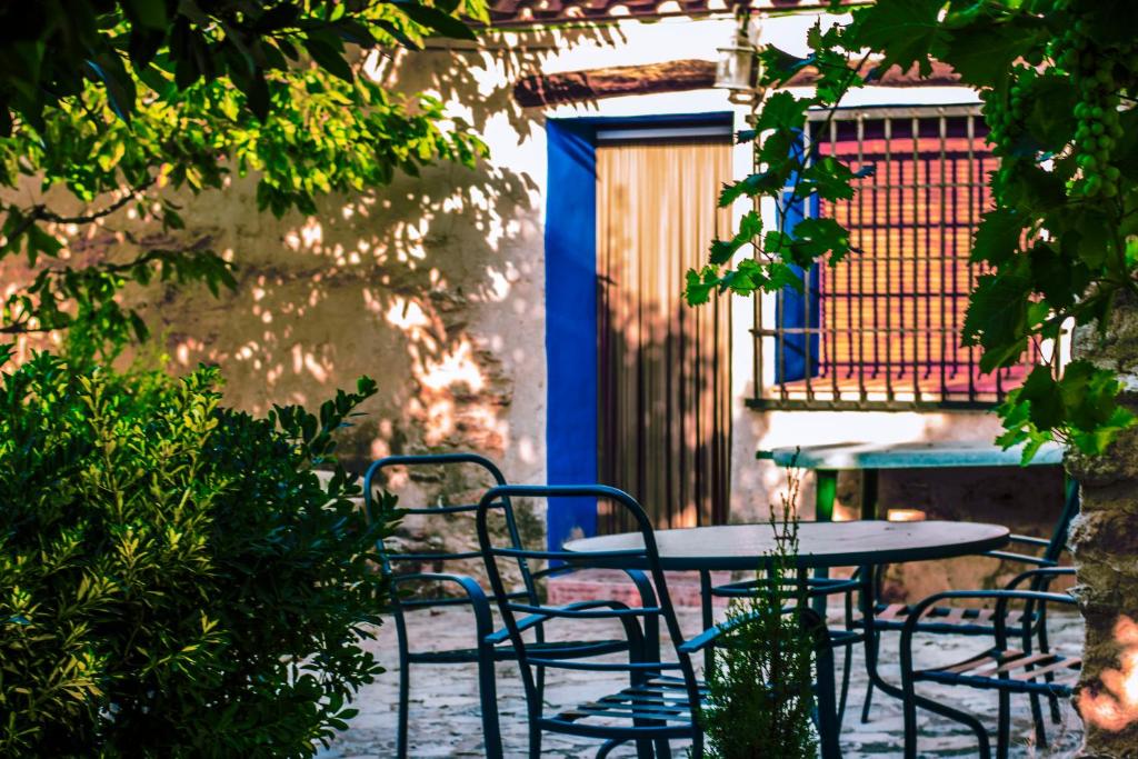 Casas Rurales Tío Segundo في Carcelén: طاولة وكراسي في فناء مع باب أزرق