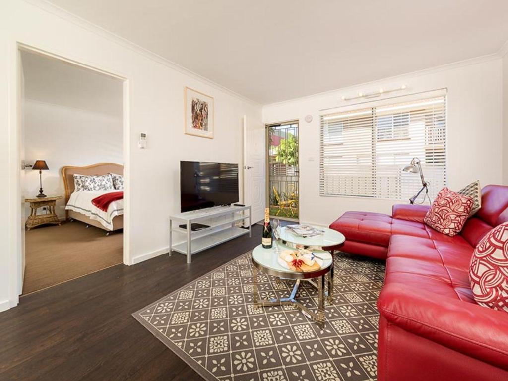 een woonkamer met een rode bank en een tv bij Understated Elegance Affordable Luxury in Albury