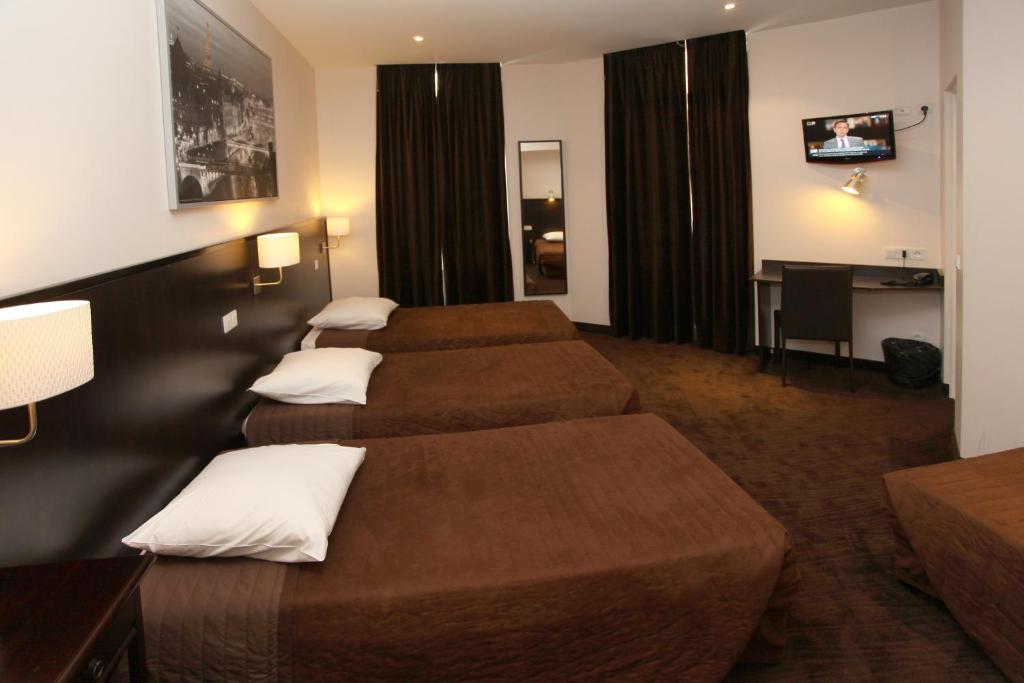 a hotel room with two beds and a television at Trocadero in Nice