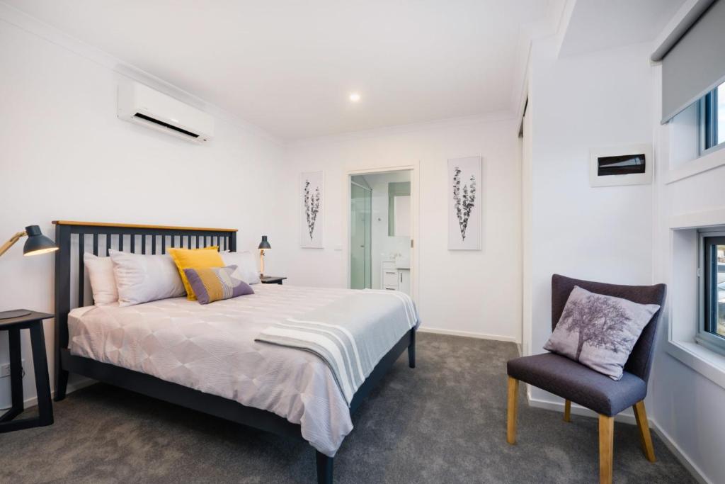 a bedroom with a bed and a chair at Albury Yalandra Apartment 2 in Albury