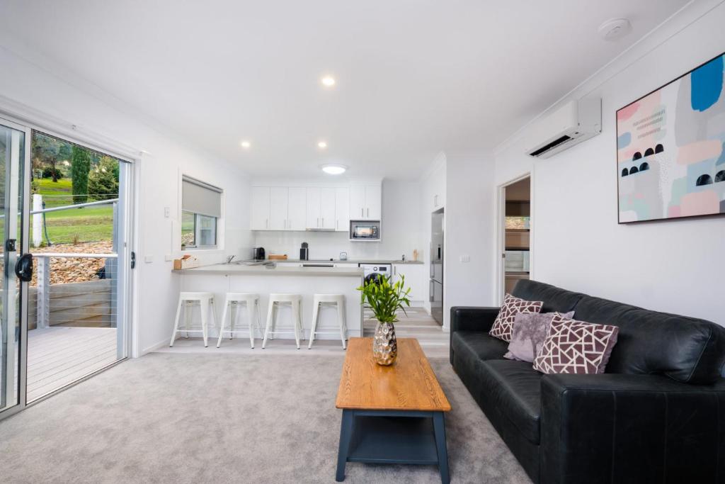 a living room with a black couch and a table at Albury Yalandra Apartment 4 in Albury