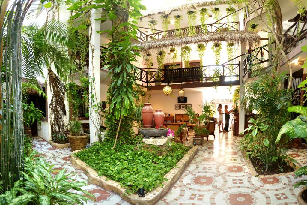 un jardín interior en un edificio con plantas en Posada Mariposa Boutique Hotel - 5th Avenue en Playa del Carmen