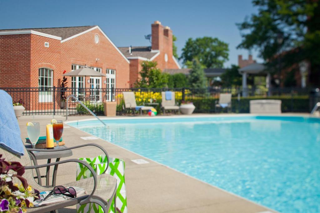 a swimming pool with a table and a chair next to it at The Ohioan Hotel and Event Center in Lewis Center