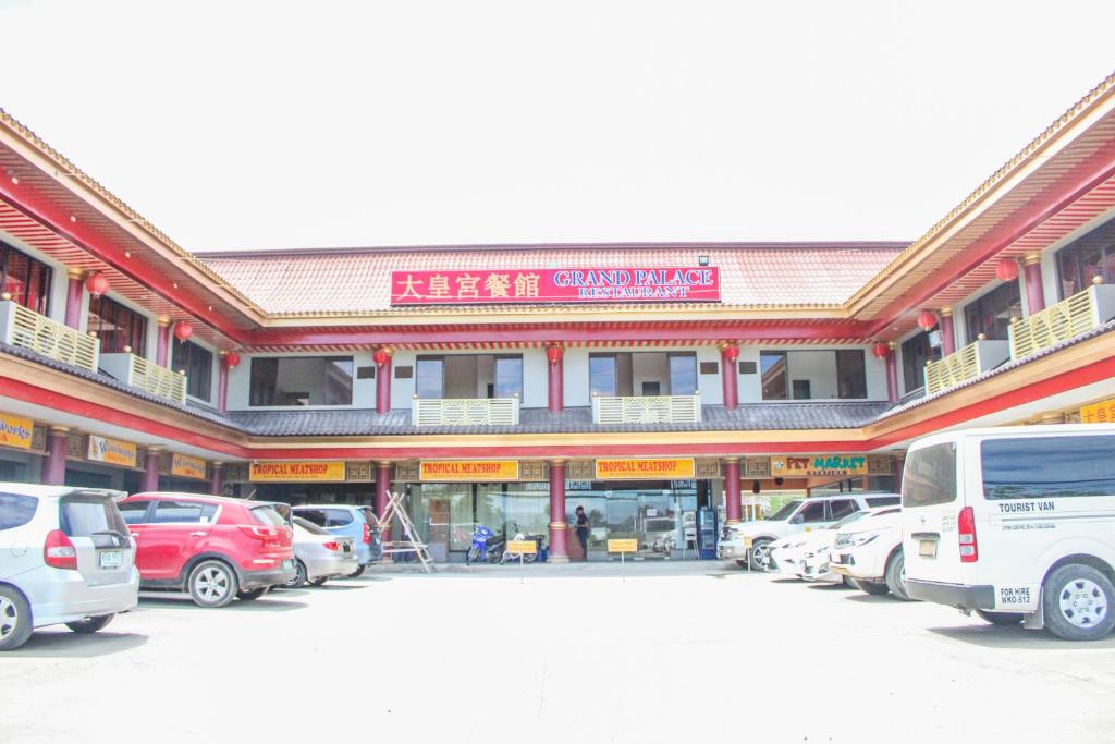 a large building with cars parked in a parking lot at Butuan Grand Palace Hotel Annex in Butuan