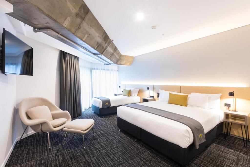 a hotel room with two beds and a tv at Song Hotel Sydney in Sydney