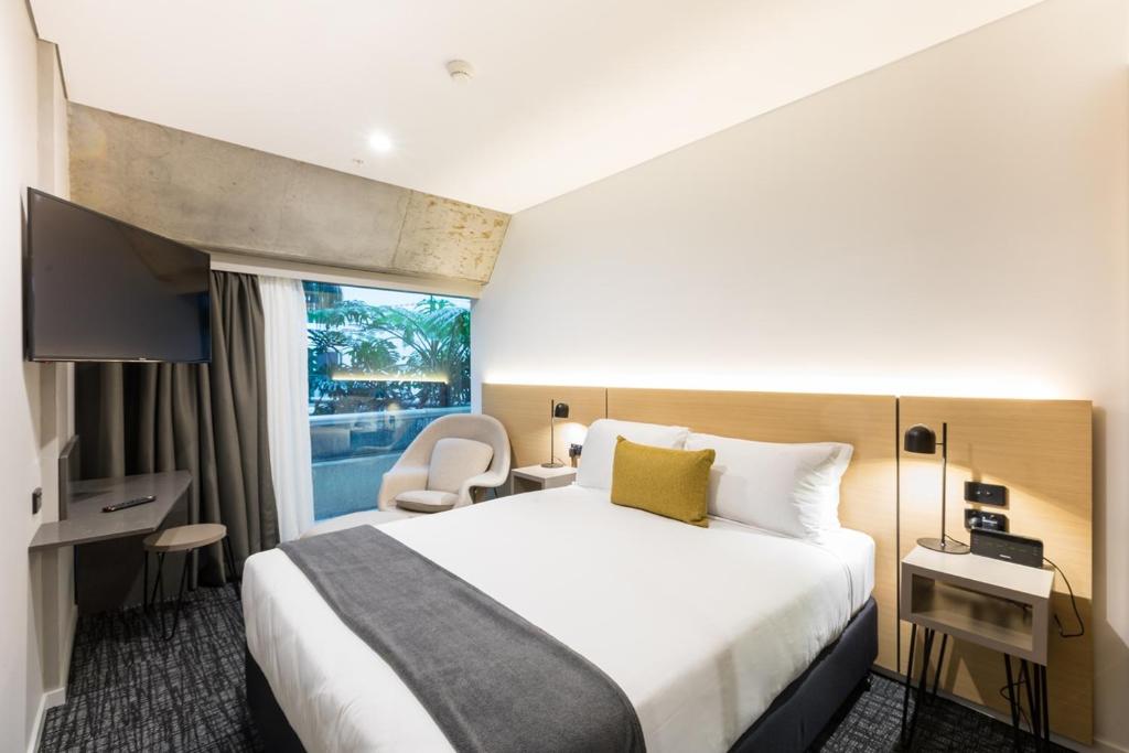 a hotel room with a large bed and a window at Song Hotel Sydney in Sydney