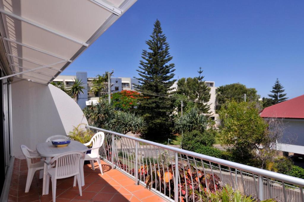 a balcony with a table and chairs on a balcony at Bright & comfortable in quiet location in Sunshine Beach