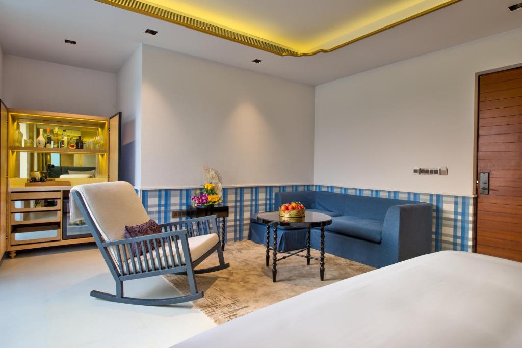 a hotel room with a bed and a chair at Azaya Beach Resort Goa in Benaulim
