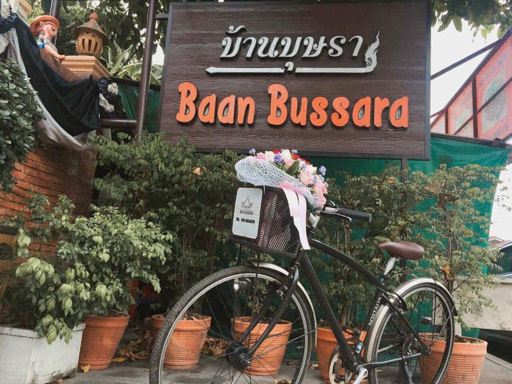 una bicicleta estacionada frente al cartel de negocios de aban en Baan Bussara, en Phra Nakhon Si Ayutthaya