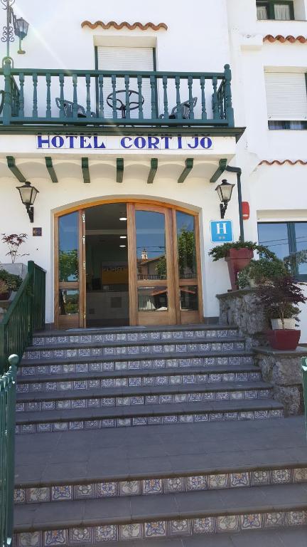 a hotel entrance with stairs in front of a building at Hotel Cortijo in Laredo