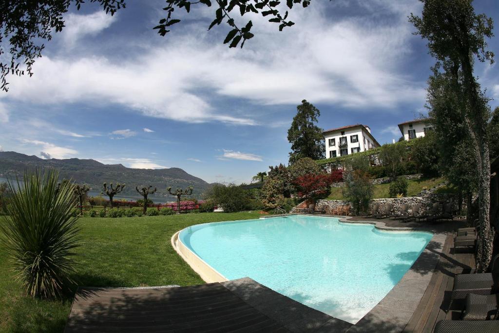 ein Schwimmbad in einem Hof mit einem Haus im Hintergrund in der Unterkunft Il Sole Di Ranco in Ranco