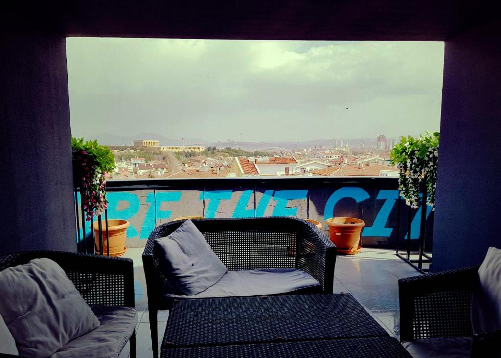 a balcony with two chairs and a view of a city at Inn 14 Hostel in Ankara