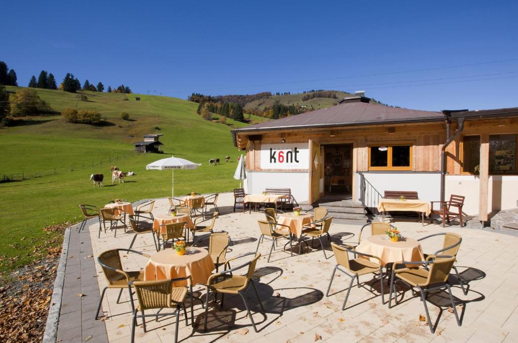 a patio with tables and chairs in front of a building at Warmingerhof in Hochfilzen