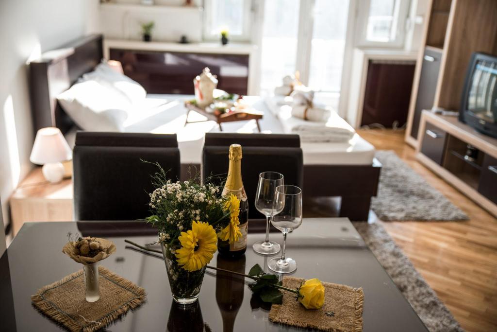 a living room with a table with wine bottles and glasses at Balkan-inn Parlament apartment in Belgrade