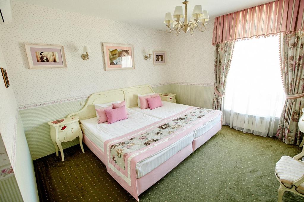 1 dormitorio con 1 cama grande con almohadas rosas en O'Hara, en Voronezh