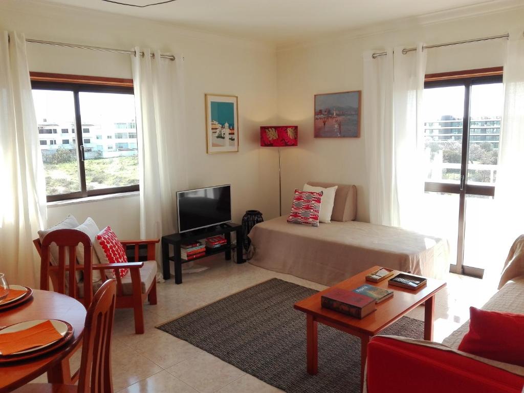 a living room with a bed and a tv at Apartamento Turf in Alvor