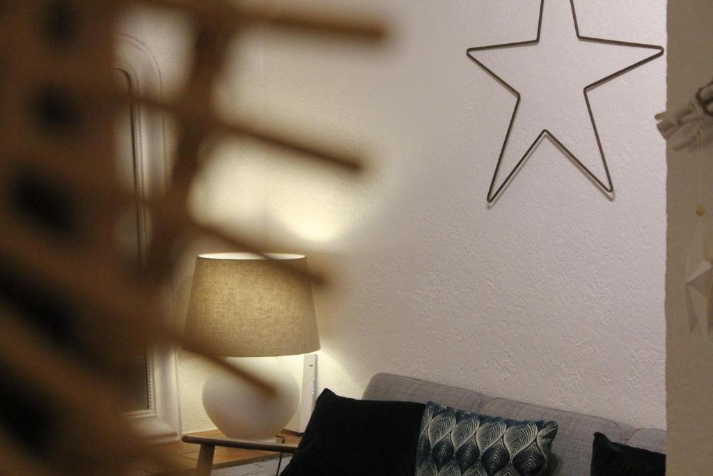 - un salon avec un canapé et une étoile sur le mur dans l'établissement StellaHome - L'Enclos, à Sanary-sur-Mer