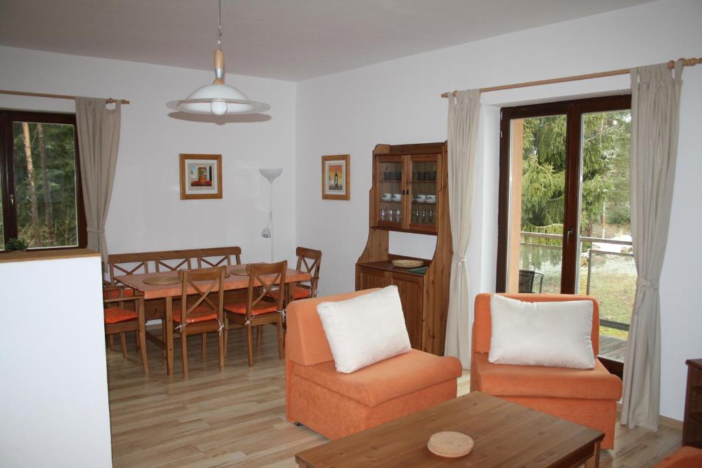 ein Wohnzimmer mit einem Tisch und Stühlen sowie ein Esszimmer in der Unterkunft Apartmány Lipno Bouček in Lipno nad Vltavou