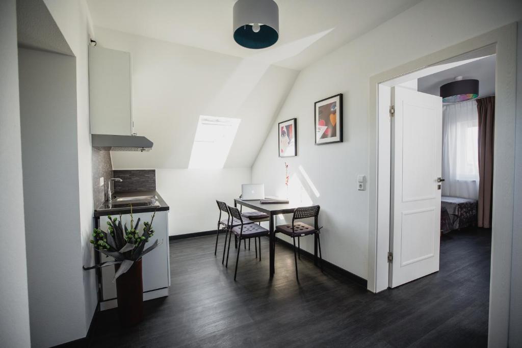 a kitchen and dining room with a table and chairs at Apartments Laatzen | contactless check-in in Hannover