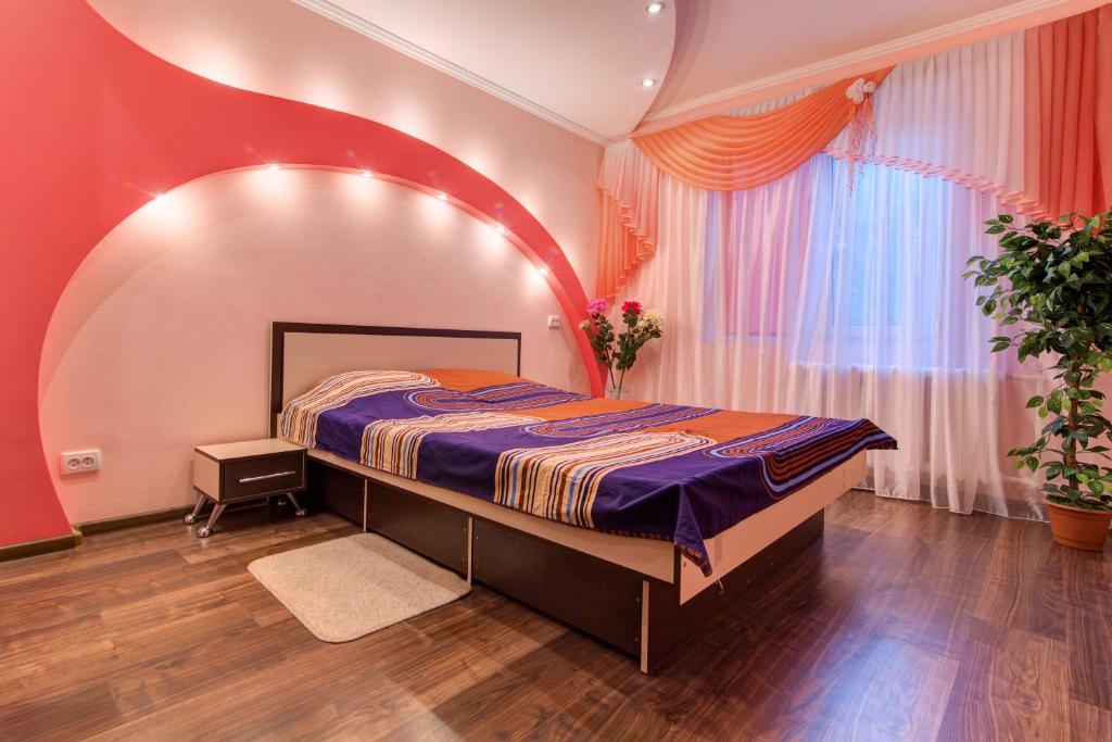 a bedroom with a bed and a large window at Apartment on Riverfront of Dnepr in Dnipro