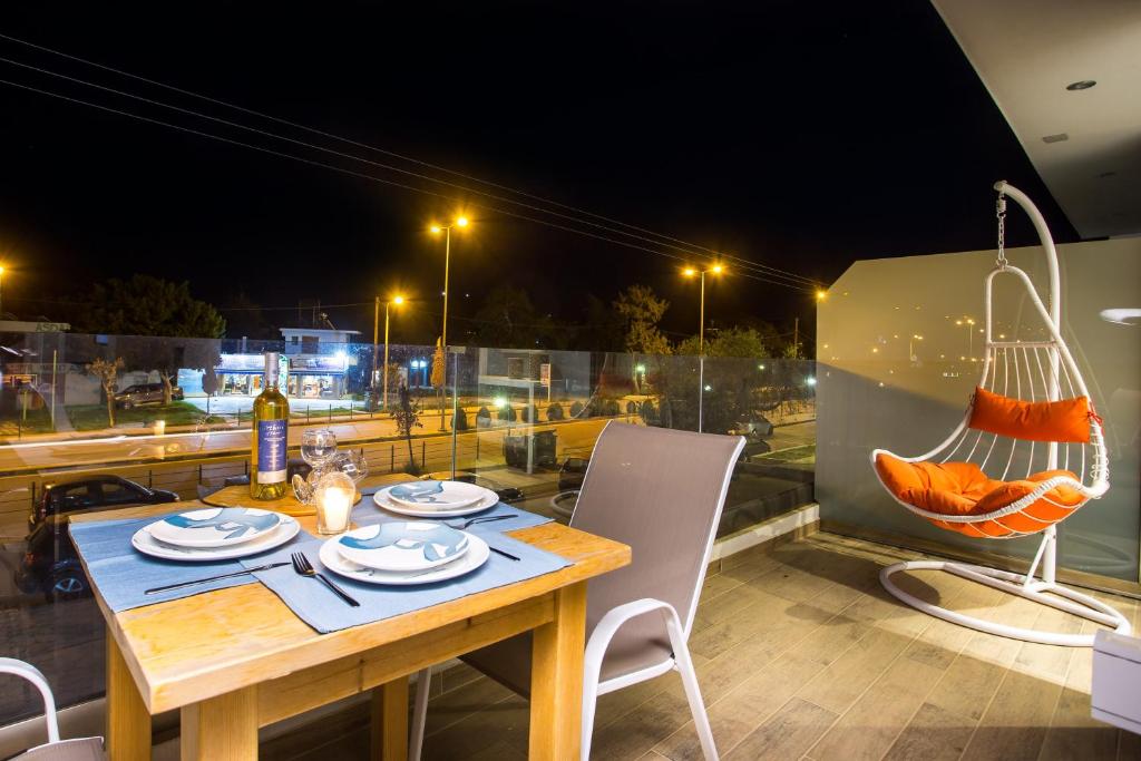 ein Tisch und Stühle auf einem Balkon in der Nacht in der Unterkunft Yianna's Flat in Faliraki