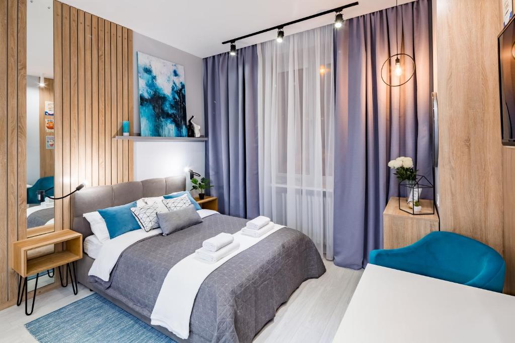 um quarto com uma cama e uma cadeira azul em Brand new studio in historical part em Lviv
