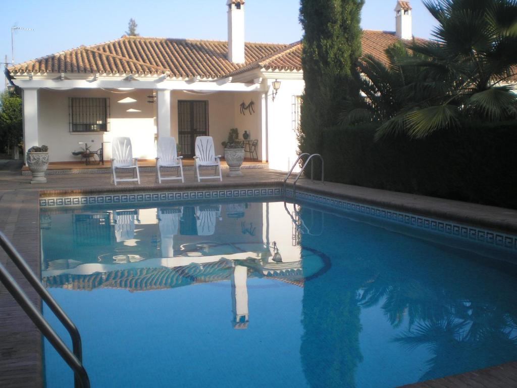 a swimming pool in front of a house at Casas del Madroño in Cazalla de la Sierra