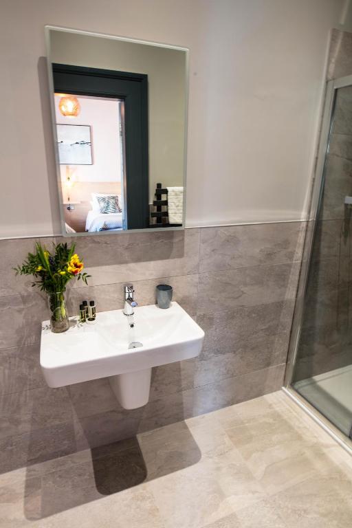 a bathroom with a sink and a mirror at The Fullerton Arms in Ballintoy
