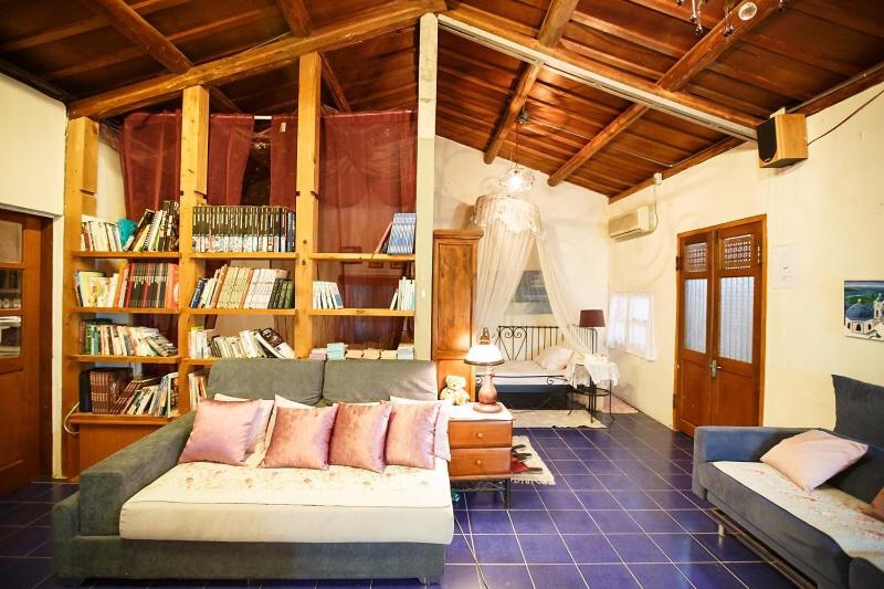 a living room with a couch and book shelves at 伊莎貝爾花園民宿 in Wanqiao