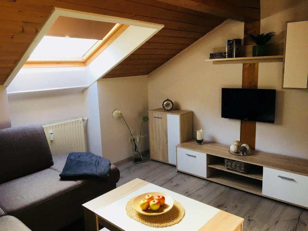 ein Wohnzimmer mit einem Sofa und einem TV in der Unterkunft Buchwinklblick in Aschau im Chiemgau