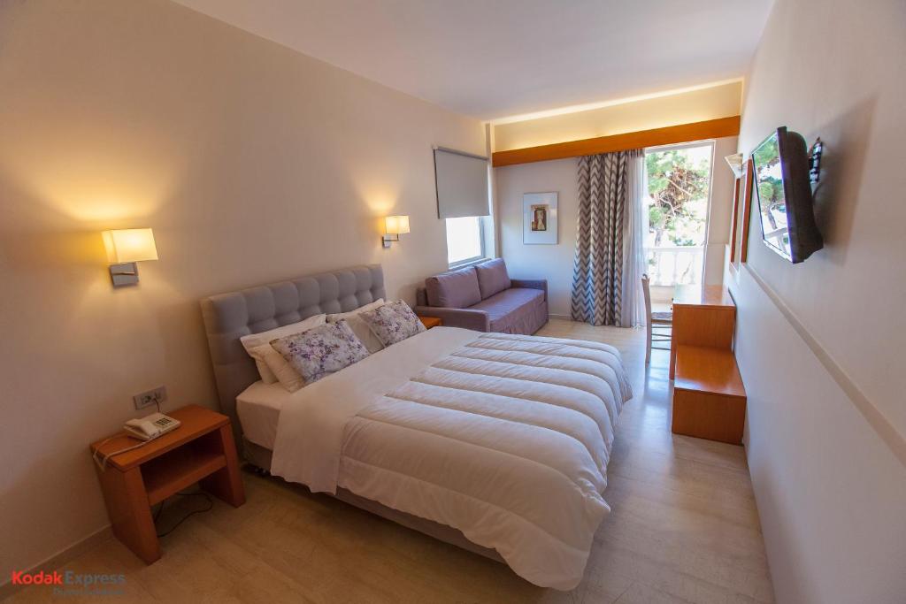 a bedroom with a bed and a living room at Antikyra Beach Hotel in Antikyra