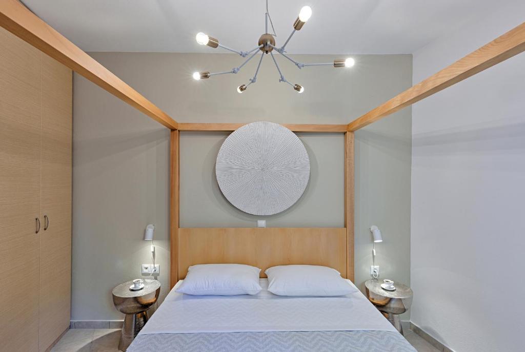 a bedroom with a bed and a mirror on the wall at Syra Bay in Megas Yialos-Nites