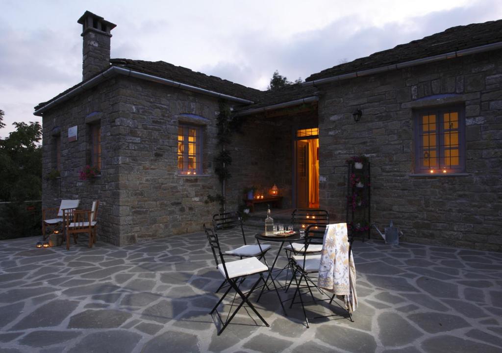 a patio with chairs and a table in front of a building at Papigo Stonehouse in Papigko