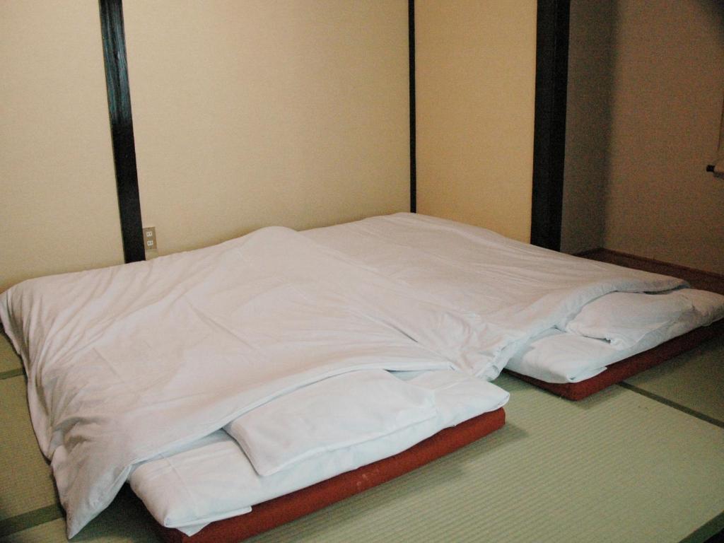 Postel nebo postele na pokoji v ubytování くさつのお宿 清重館 Kiyoshigekan 素泊りの宿