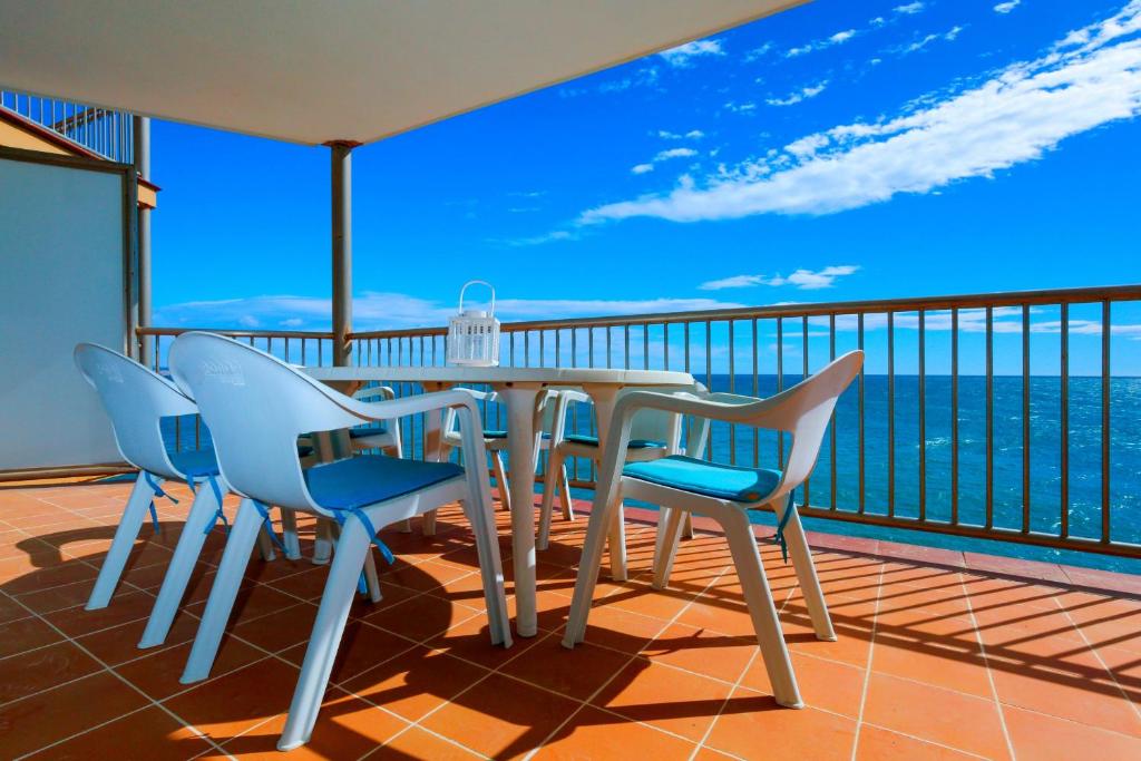 サロウにあるAquamar Planet Costa Dorada ONLY FAMILIESのテーブルと椅子、海の景色を望むバルコニー