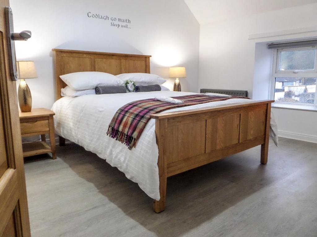 a bedroom with a large bed and a window at Antrim Coast Apartments in Cushendall