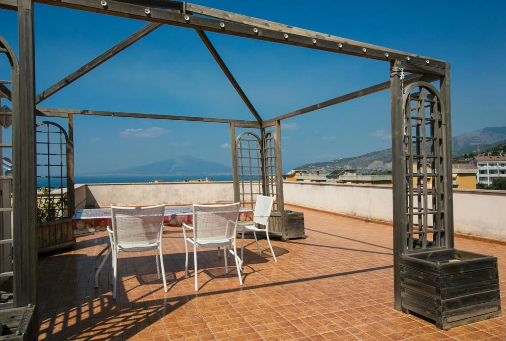 a gazebo with chairs and a table on a roof at Albatros Sorrento in Sorrento