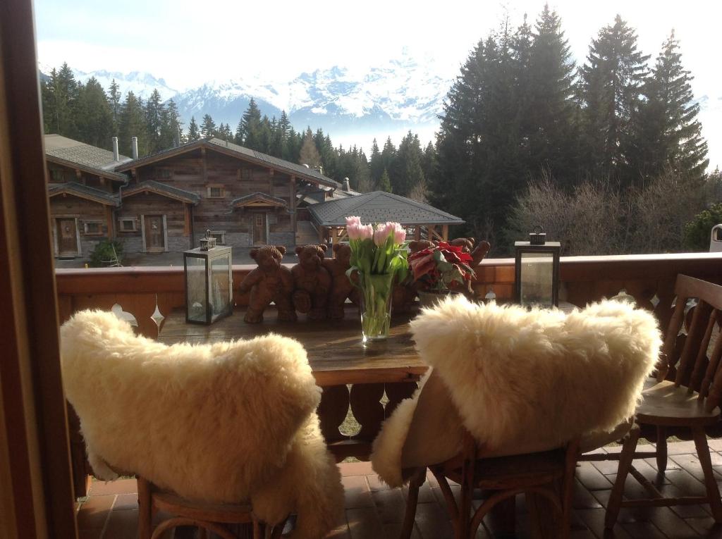 a table with two furry chairs and a table with flowers at Petit Ours in Villars-sur-Ollon