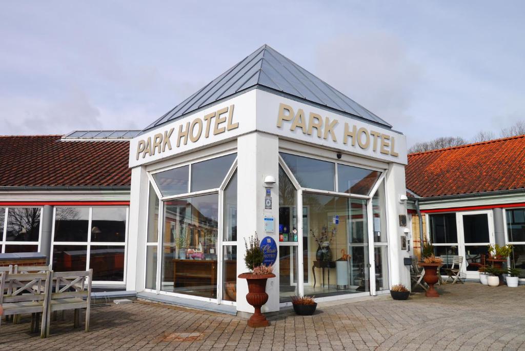 een park hotelgebouw met een parkeerplaats bij Montra Odder Parkhotel in Odder