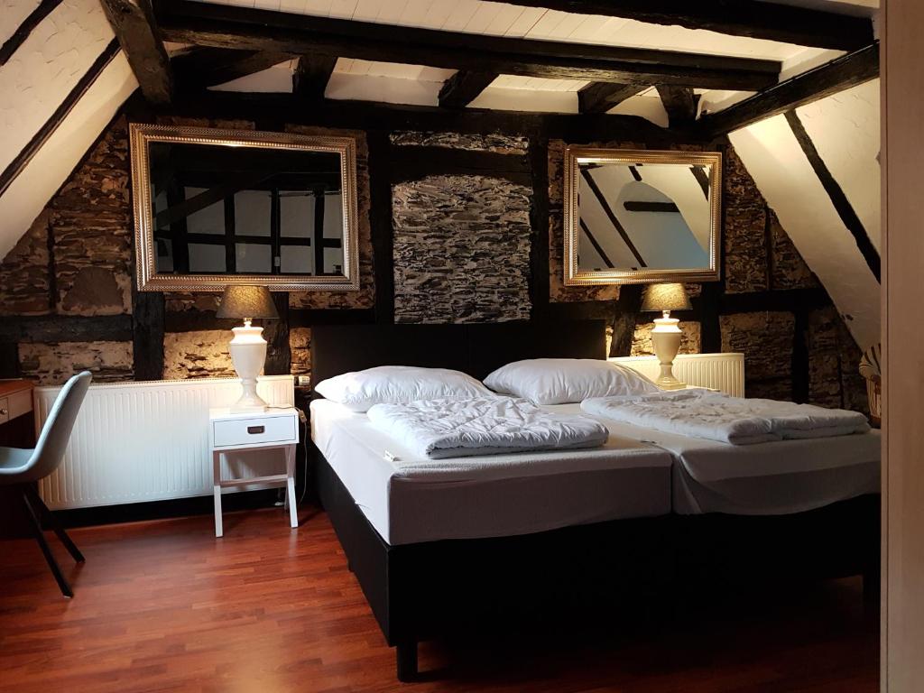 a bedroom with two beds in a room with two lamps at Haus Am Bachgasse in Zell an der Mosel