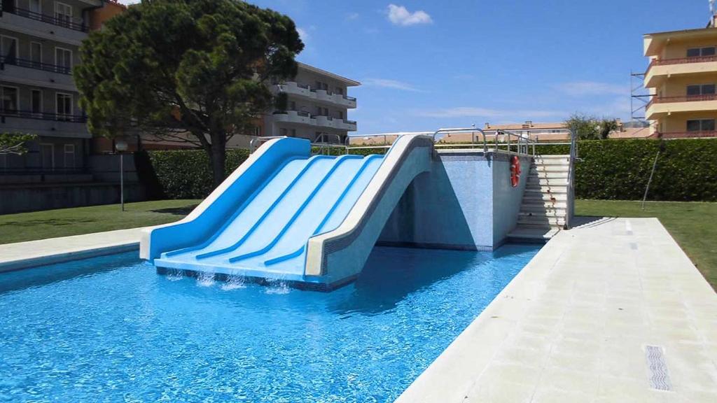 un tobogán azul en medio de una piscina en Sistach Rentals Apartments Blau Park 310 & 311 en L'Estartit