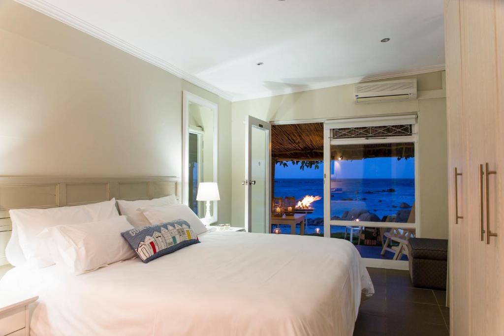 a bedroom with a bed with a view of the ocean at Piccolo Villa in St Helena Bay