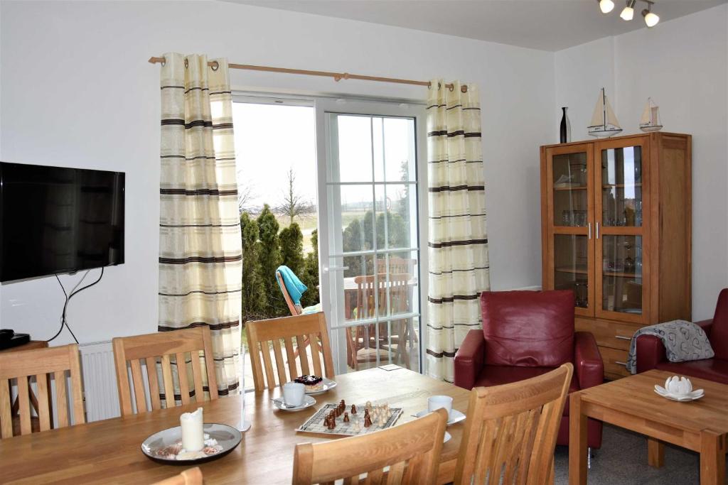 a living room with a dining table and a television at Apartment - Direkt am Wasser in Ostseebad Karlshagen